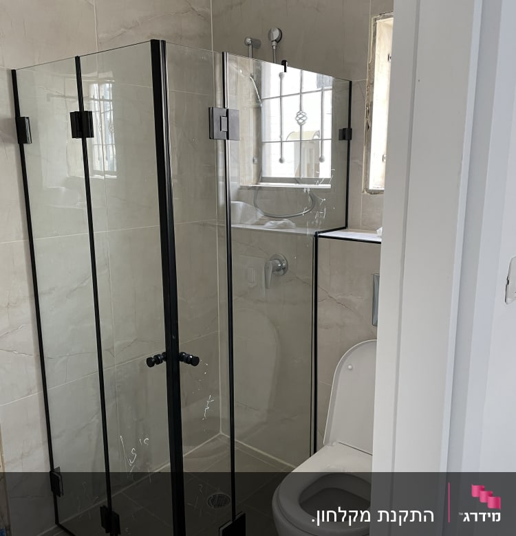 מקלחון זכוכית עם דלתות שחורות בחדר אמבטיה